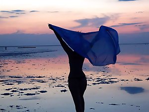 On sand seminude with light-color vase